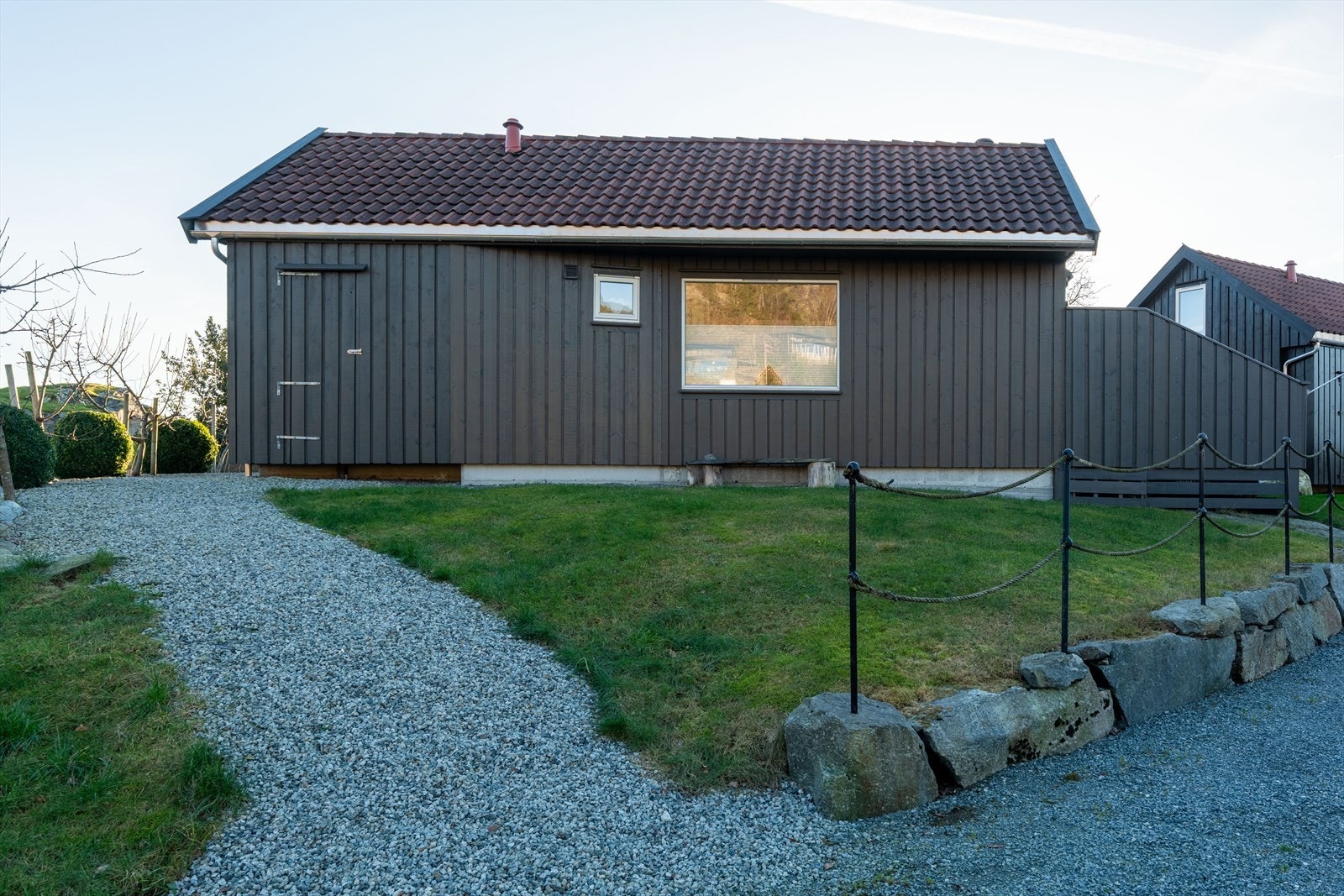 Flott opparbeidet tomt med plen og gruslagt inngang Galleribilde