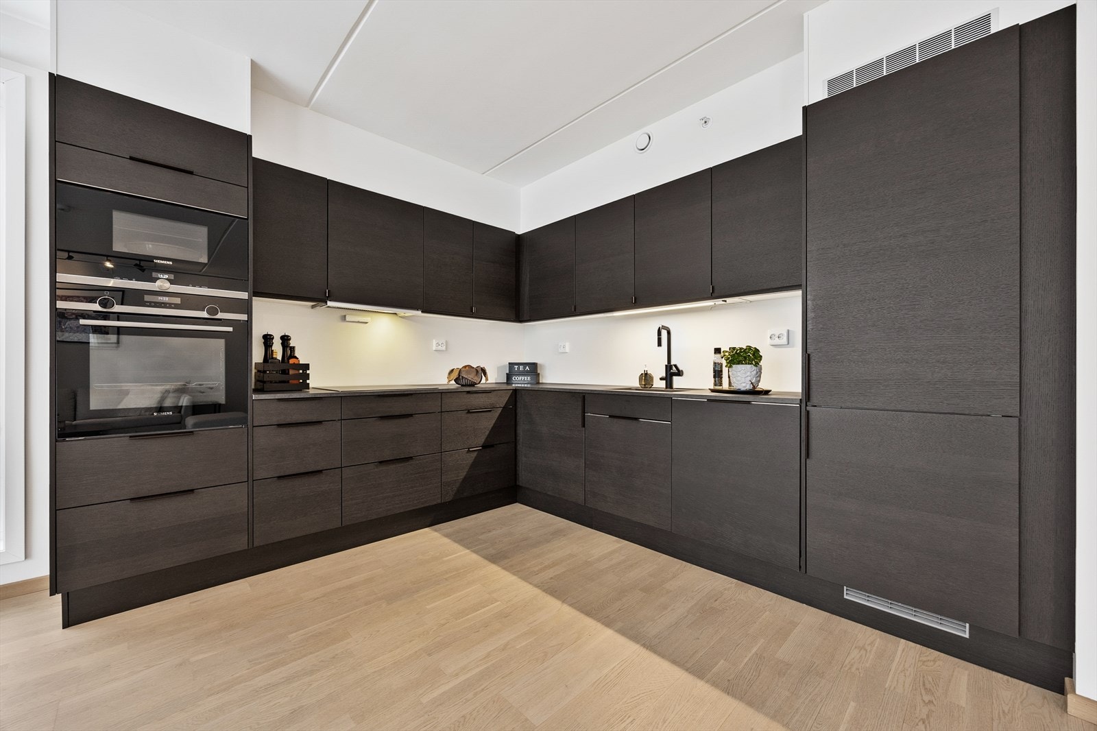 Innredningen består av mørke/glatte fronter, benkeplate i laminat og en skyllekum i plastkompositt Galleribilde