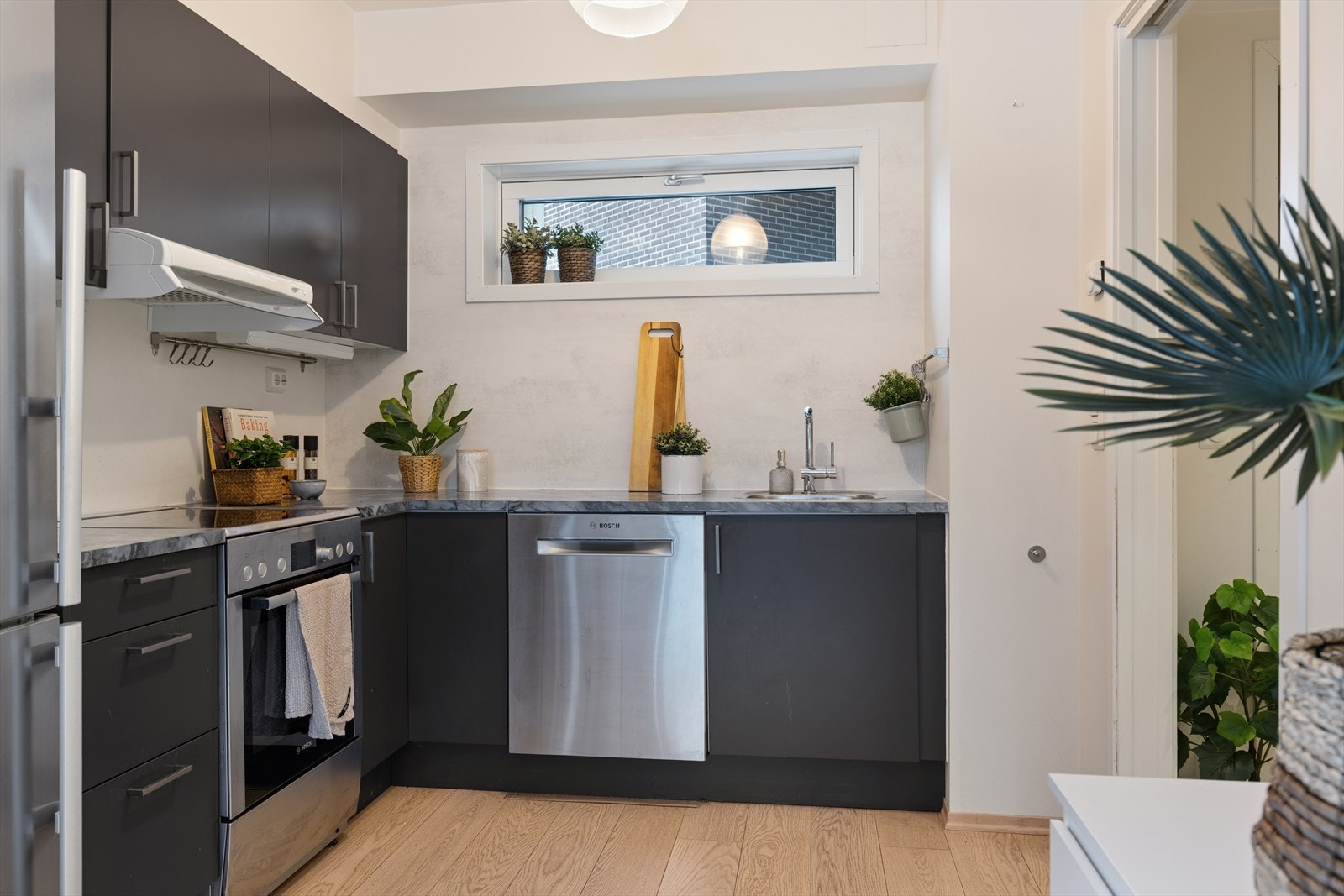 Velutstyrt kjøkken med laminert benkeplate og nedsenket oppvaskkum, samt induksjonstopp og integrerte hvitevarer. Galleribilde