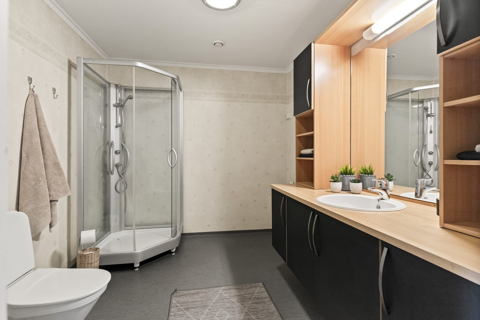 Badet har belegg på gulv og våtromstapet på veggene. Opplegg for vaskemaskin i hjørnet. Galleribilde