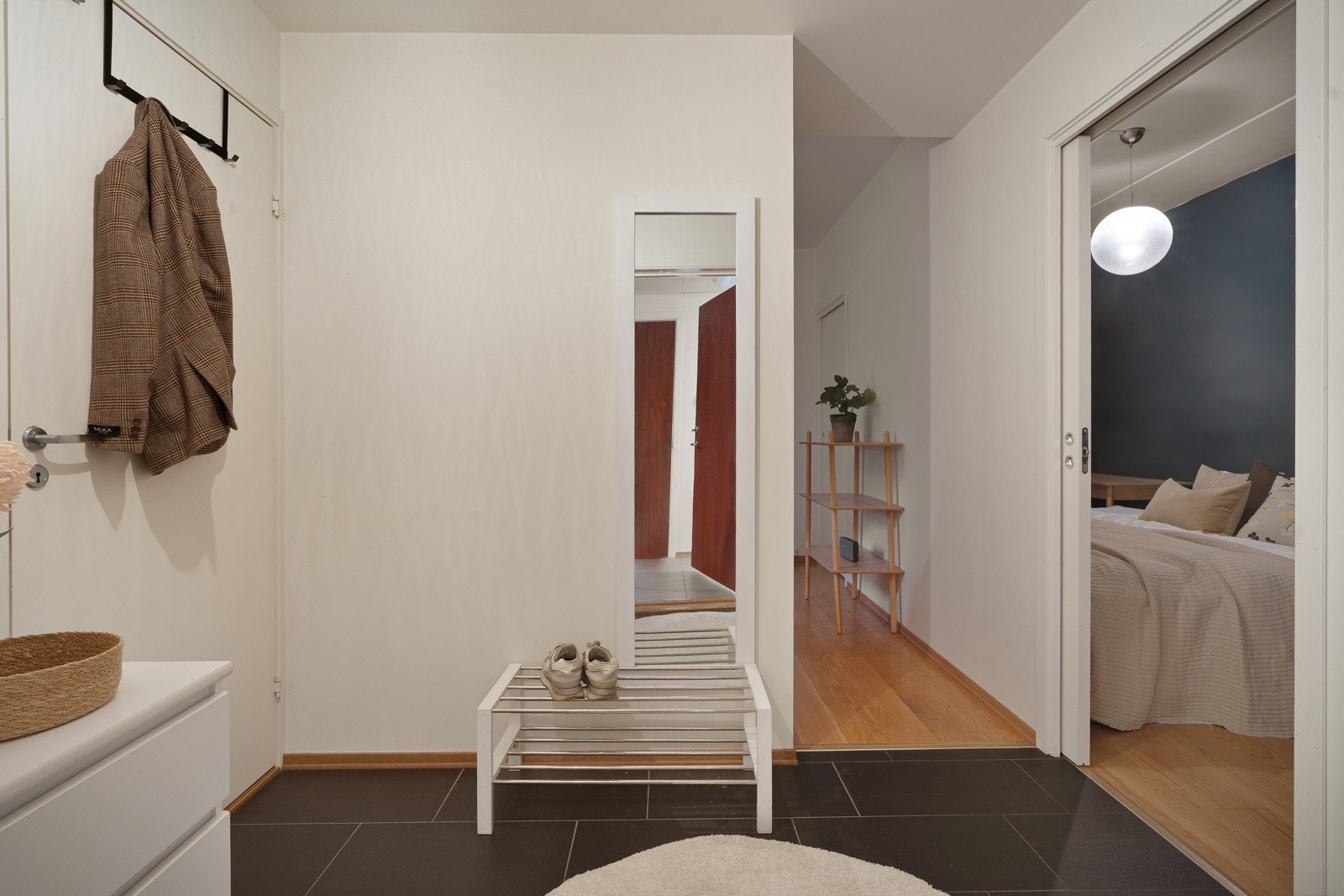 Flislagt entrè med muligheter for å etablere smarte løsninger for yttertøyet.