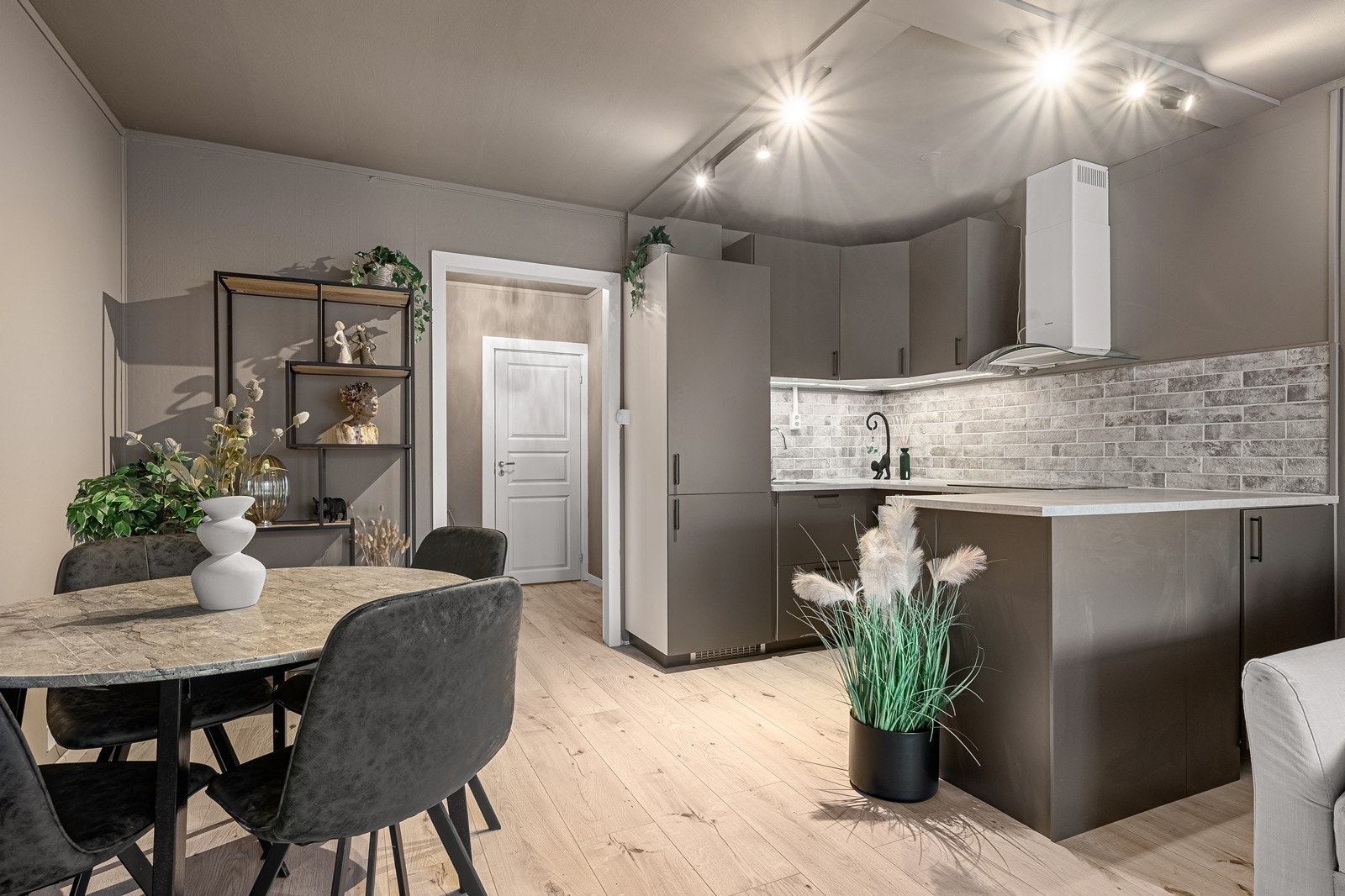 Kjøkkenet ligger i åpen løsning, med innredning i u-form som både er en god romdeler og gir godt med skap- og benkeplass Galleribilde