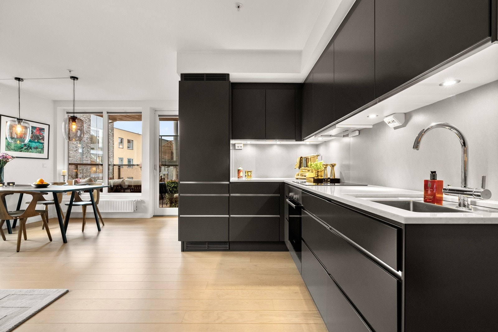 Både fint og praktisk med fliser i benkeryggen og belysning under overskapene. Galleribilde