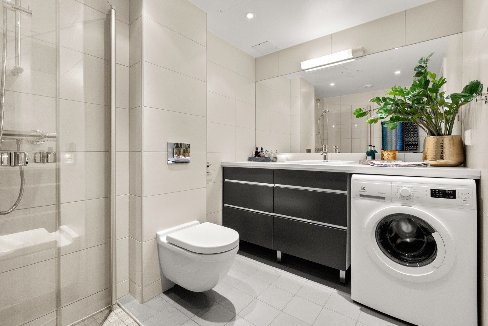 Baderommet er også utstyrt med dusjhjørne med innfellbare glassdører og vegghengt toalett. Galleribilde