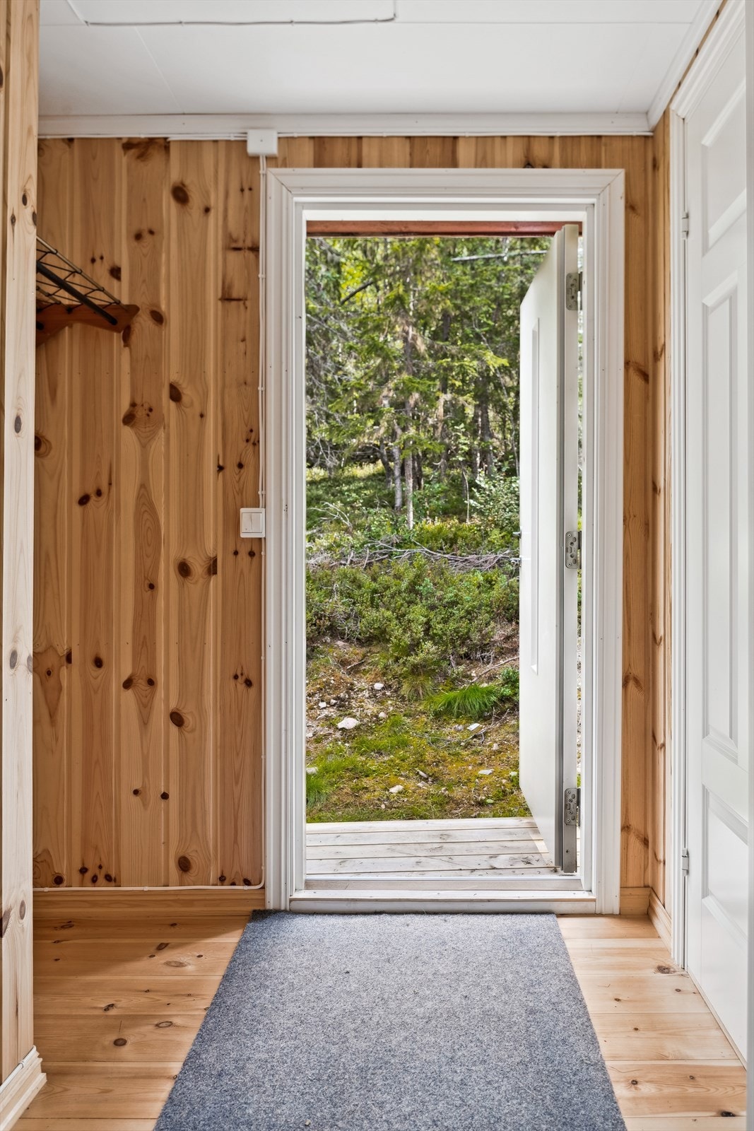 Her kommer man inn i en romslig gang med adkomst til bod og innergang. Vegghengt hylle med knagger hvor man kan henge fra seg yttertøyet. Galleribilde
