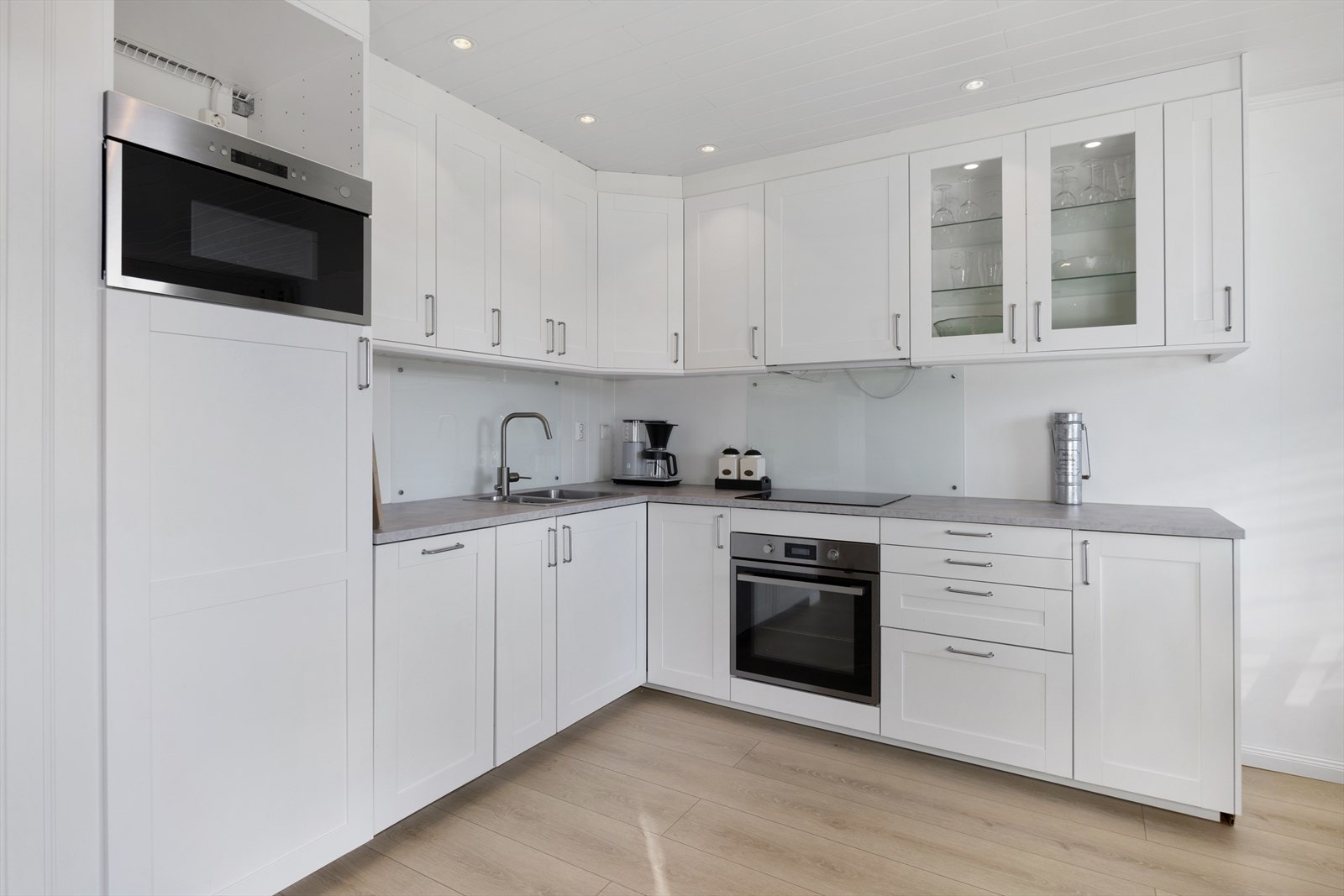 Lyst og tiltalende kjøkken med profilerte fronter og laminert benkeplate. Kjøkkenet er utstyrt med integrert oppvaskmaskin, stekeovn og koketopp. Galleribilde