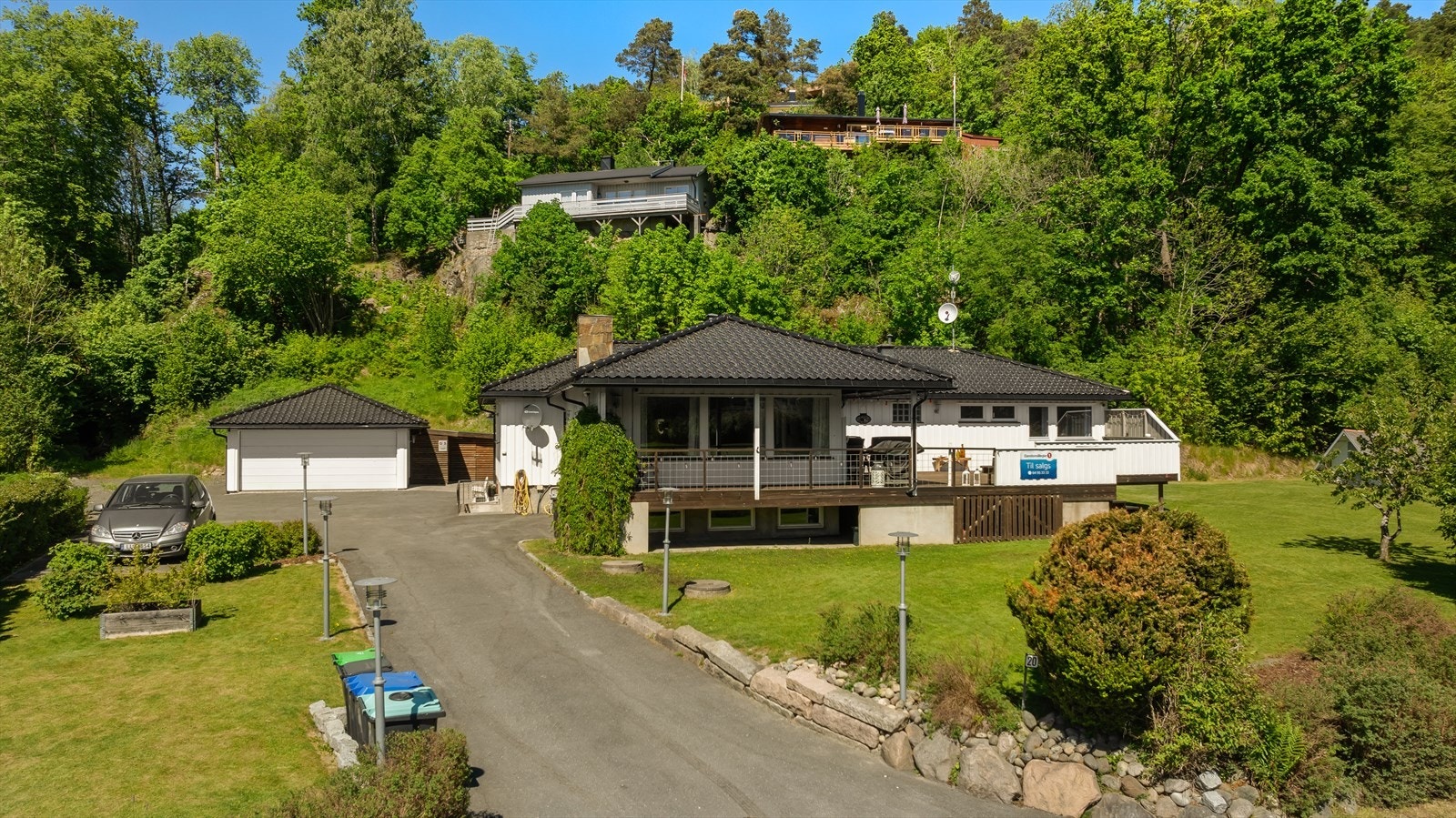 Tomten er opparbeidet med stor asfaltert gårdsplass, med plass til flere biler. Eiendommen består av enebolig og frittstående dobbelgarasje. Galleribilde