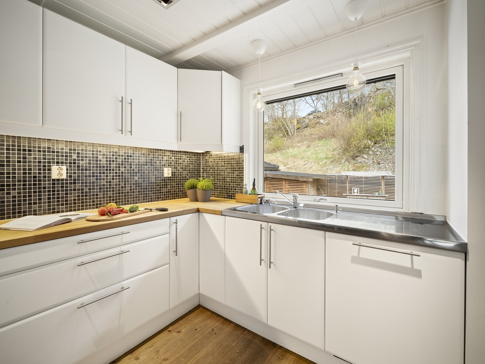 Det funksjonelle kjøkkenet utnytter plassen godt, og den romslige benkeplassen gjør matlagingen både enkel og effektiv. Galleribilde