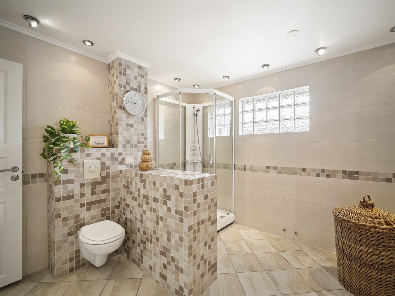 Badet har vegghengt klosett og dusjkabinett Galleribilde