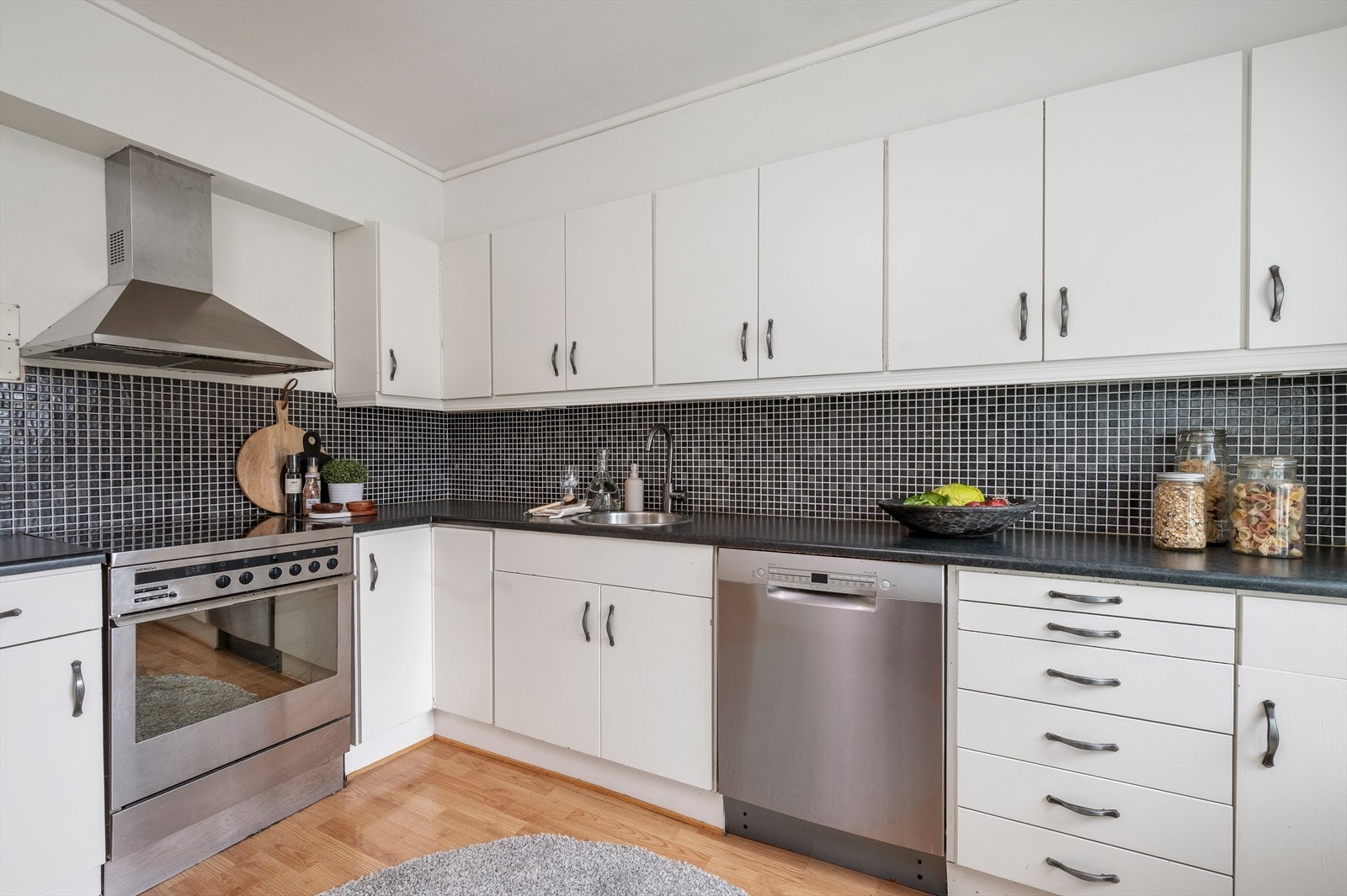 Lyst kjøkken med mye skap og benkeplass. Galleribilde