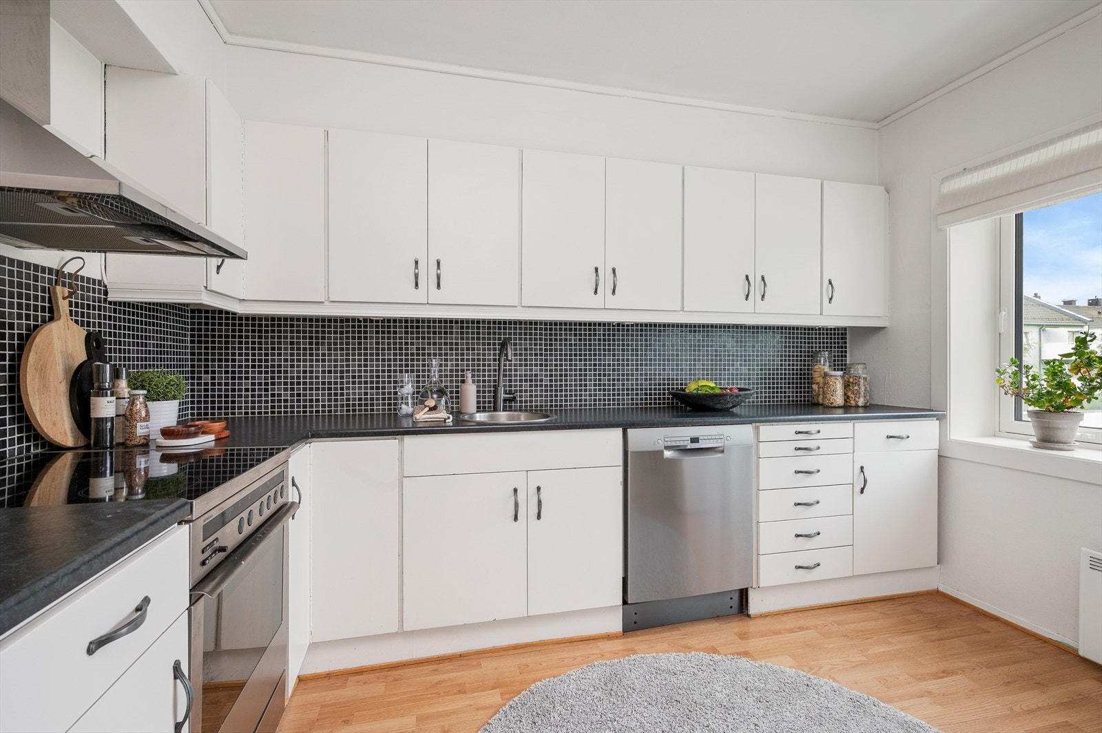 Kjøkkenet har folierte skrog med slette fronter og laminert benkeplate. Flis på vegg over benkeplate. Opplegg for kjøleskap, oppvaskmaskin og stekeovn. Galleribilde