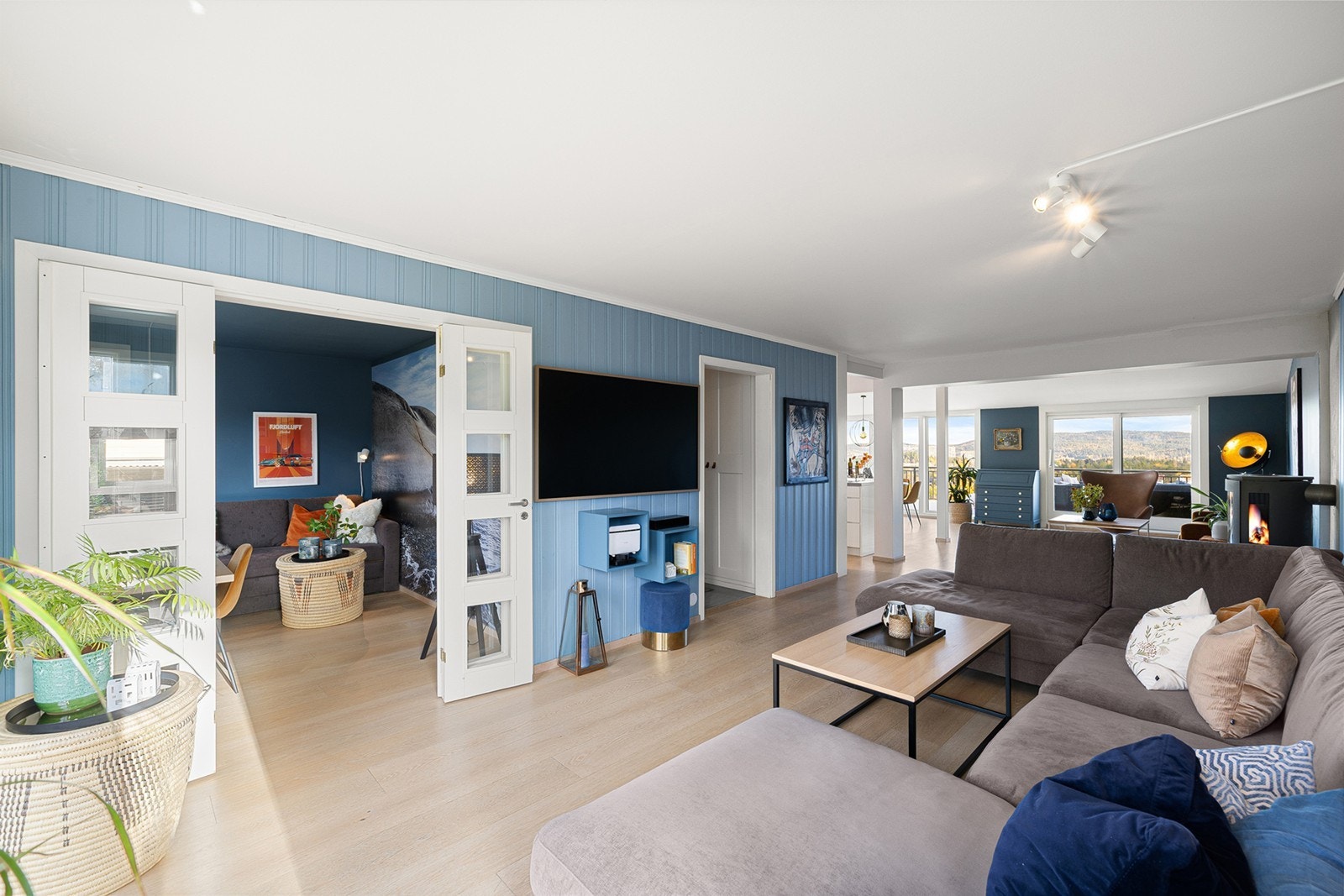 Rommet har god plass til både sofagruppe og spiseplass, og de gjennomgående materialvalgene skaper en harmonisk og lun atmosfære. Galleribilde