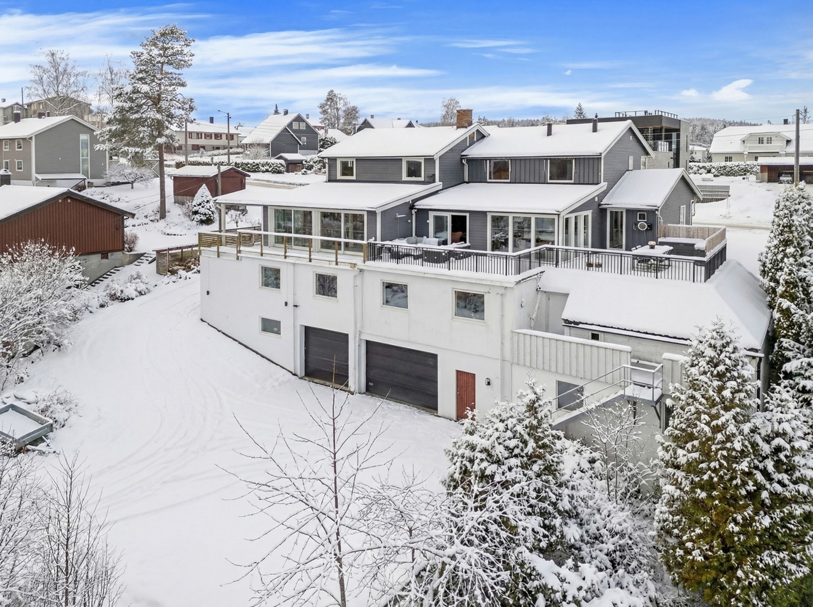 På baksiden av huset er det stor garasje og rikelig med plass til både egne og gjesters biler. Det er montert elbil-lader på forsiden av huset. Galleribilde