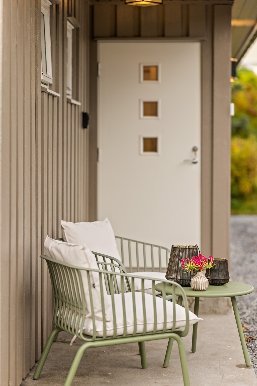 Overbygd inngangsparti med plass til liten sittegruppe. Galleribilde