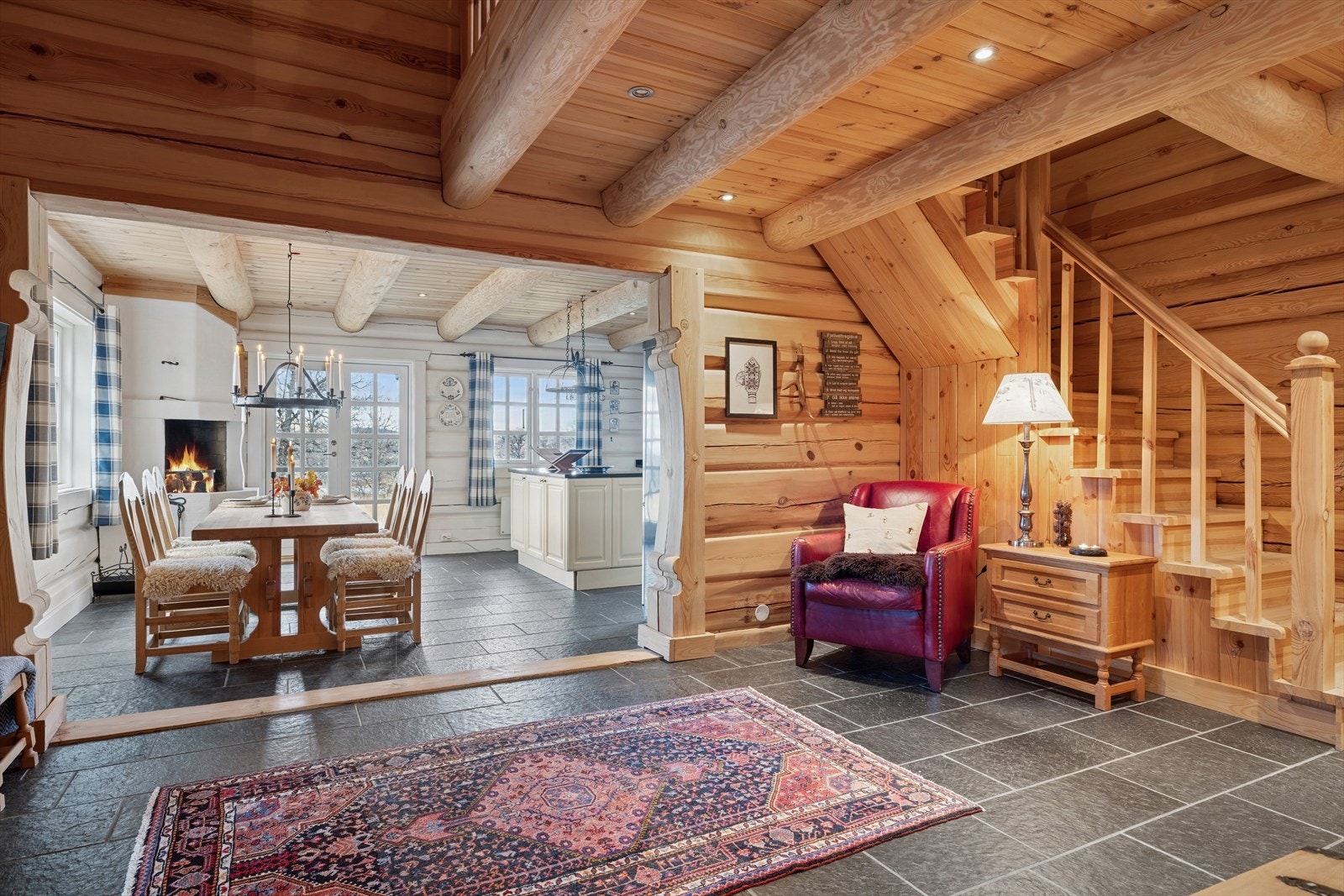 Innbydende hall, hyttas naturlige knutepunkt. Herfra har du adkomst til soveromsfløyen, stuen og kjøkkenet. Gulvet er belagt med skiferfliser med varmekabler, som gir både stil og komfort. Galleribilde