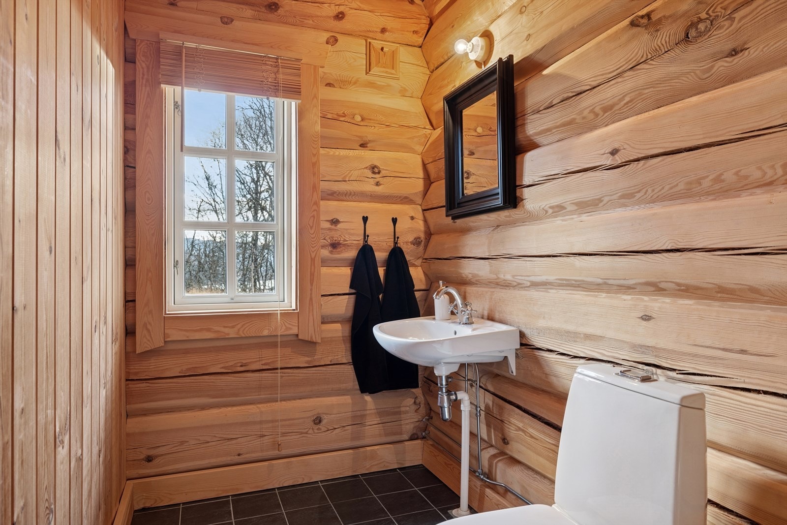 Praktisk løsning med ekstra toalettrom separat i første etasje, plassert i soveromsfløyen. Perfekt når hytta er full av gjester. Galleribilde