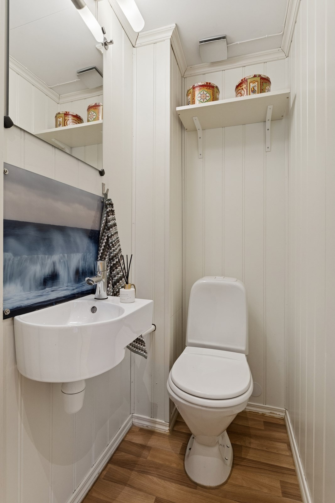 Separat toalettrom med vegghengt servant og gulvmontert toalett gir et enkelt og funksjonelt rom. Mekanisk avtrekk sørger for effektiv ventilasjon. Galleribilde