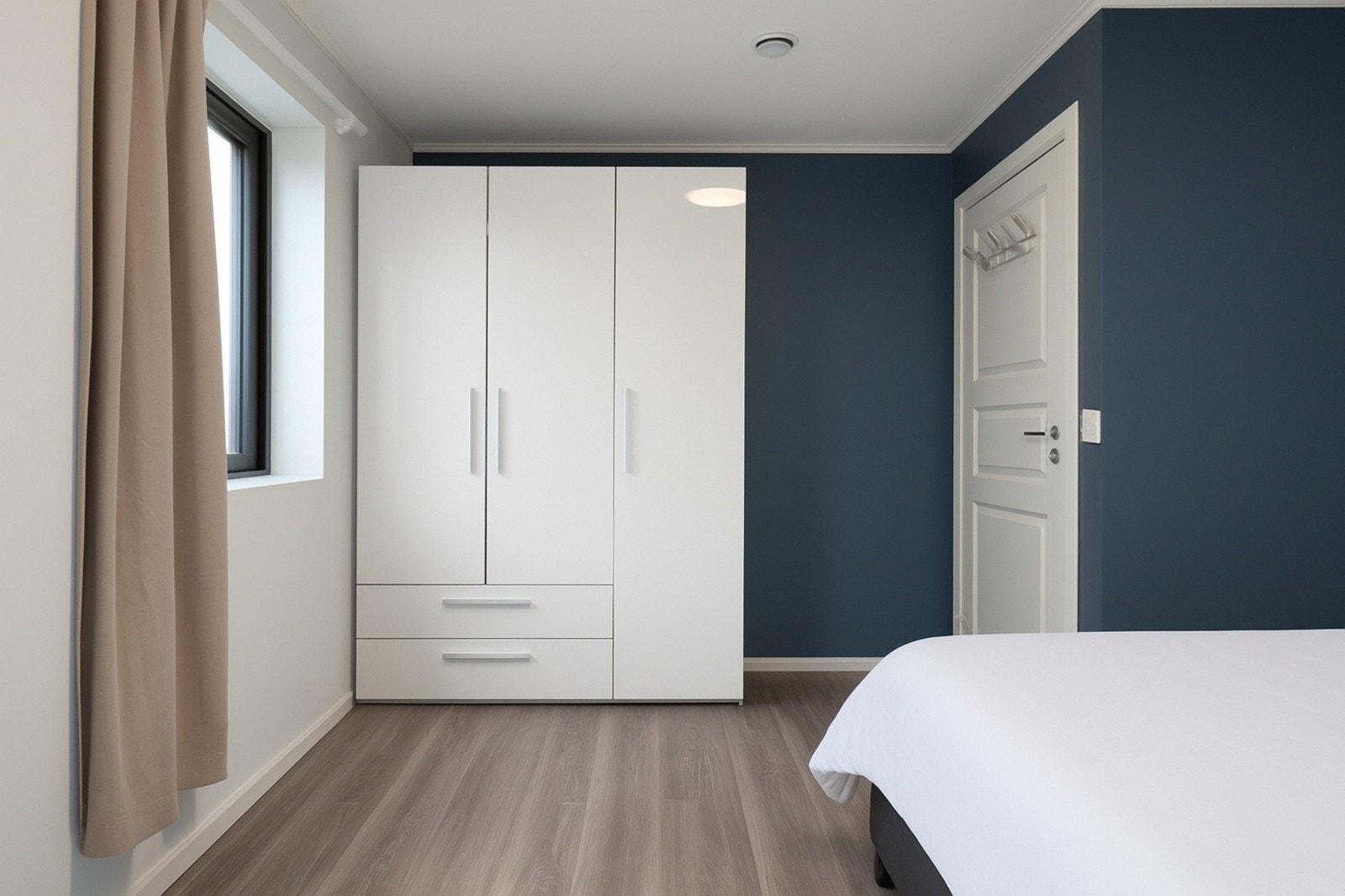 Soverom med smart oppbevaring og stilrene farger. Galleribilde