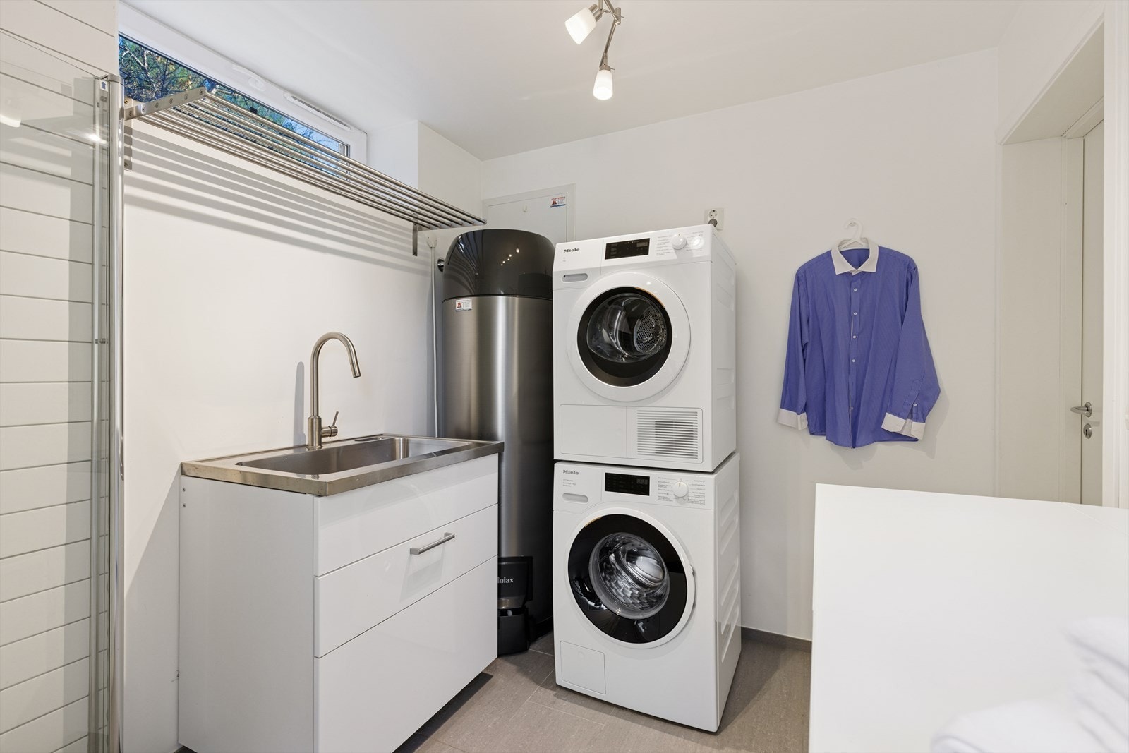 Rommets innredning består av en vaskeromsinnredning med servant, klesoppheng og dusj med innfellbare dusjdører. Det er i tillegg opplegg for vaskemaskin og plass til tørketrommel. Galleribilde