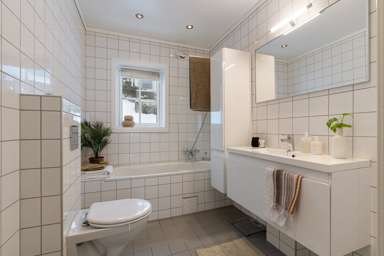 Fliselagt bad med elektriske varmekabler og downlights i himling. Galleribilde