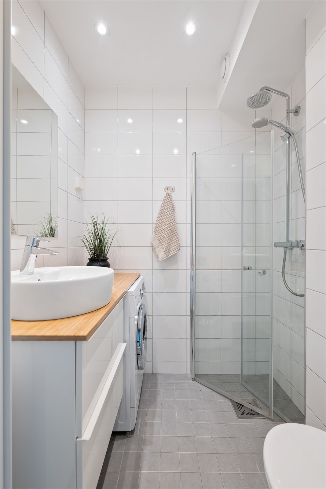 Moderne og innbydende bad med flislagte overflater, downlights i himlingen og elektrisk varme i gulvet. Galleribilde