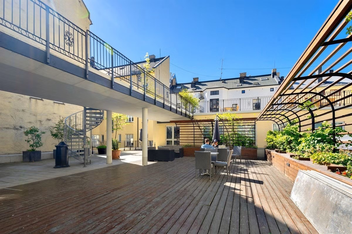 Flott gårdshage med flere sitteplasser og beplantning Galleribilde