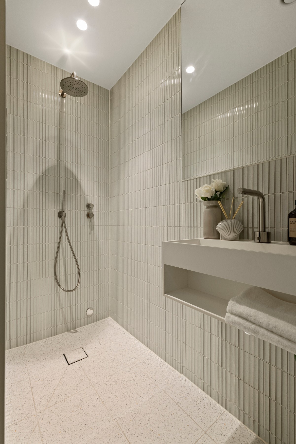 Det er behagelig gulvvarme og baderomsinnredningen består av vegghengt servant med hylle under og vegghengt speil. Galleribilde