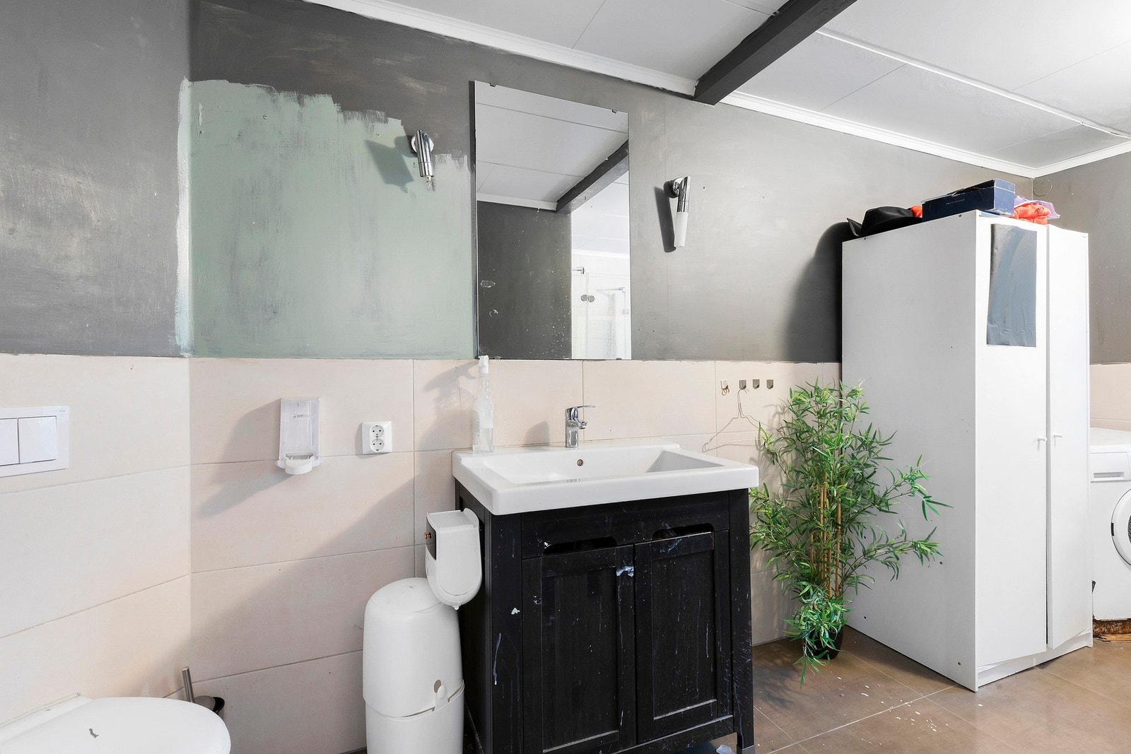 Bader er innredet med åpen dusjplass med innfellbare dusjdører, vegghengt WC, kran og avløp for vaskemaskin, samt servant. Galleribilde