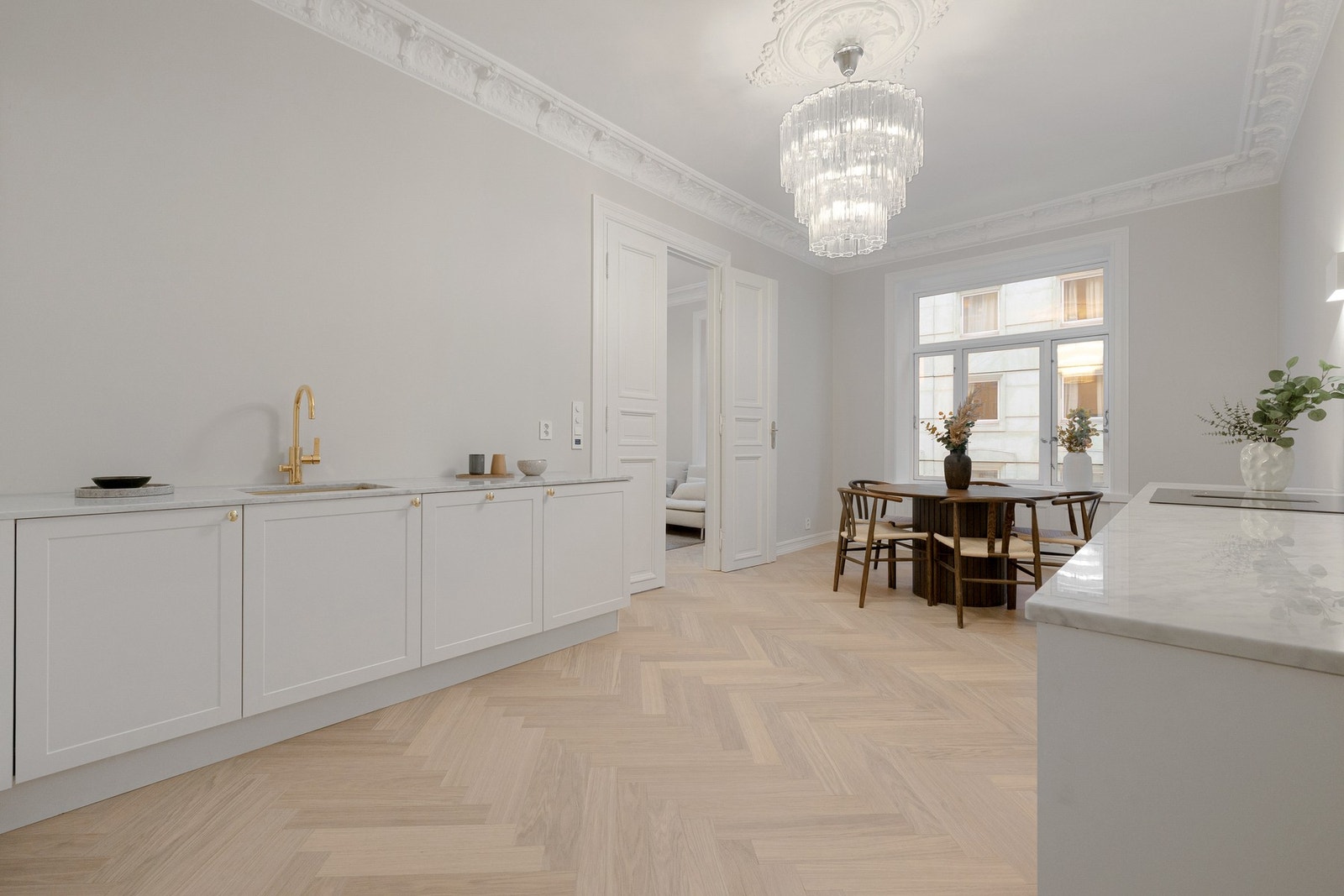 Helt nytt og lekkert kjøkken i 2025 med svært eksklusiv benkeplate i italiensk carrera-marmor. De profilerte frontene sammen med stukkaturen, rosetten og takhøyden på 3 meter komplementerer det klassiske uttrykket i leiligheten. Håndtak i messing. Galleribilde