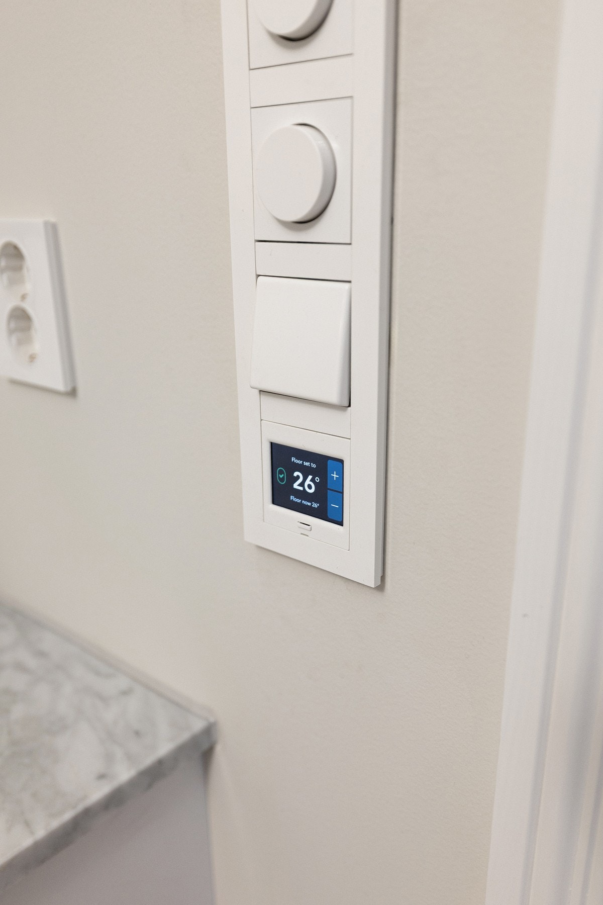 Italiensk Carrera-marmor benkeplate og termostatstyring til varmekabler på gulv - klassisk eleganse og moderne komfort i sømløs kombinasjon. Galleribilde