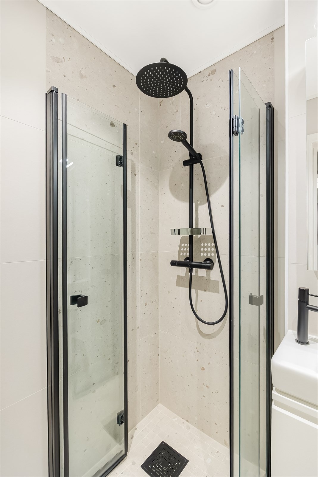 Dusjnisje med to svingbare glassdører, tilkoblet hånd- og regndusj. Galleribilde