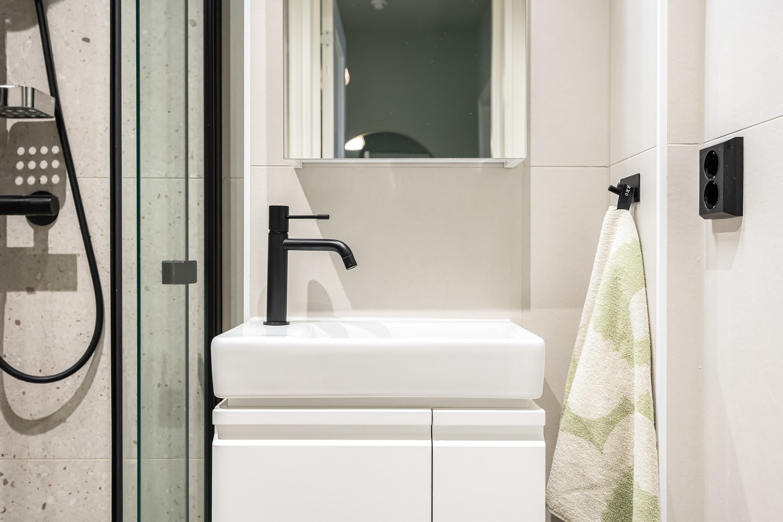 Badet er innredet med vegghengt toalett og servant med heldekkende vask, samt speilskap med overlys over servant. Galleribilde