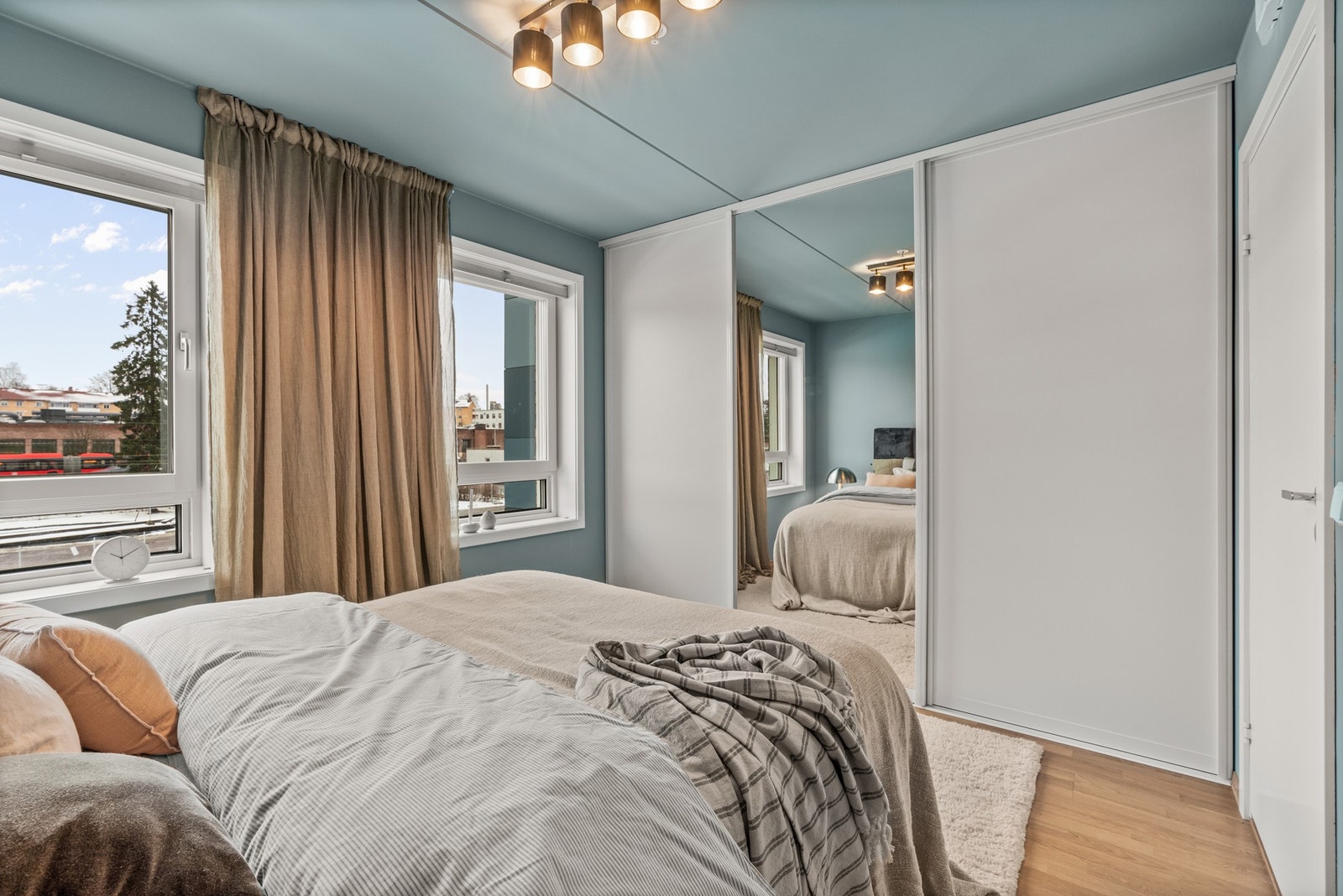 Rommet har en stor skyvedørsgarderobe med speilfront for oppbevaring av klær Galleribilde