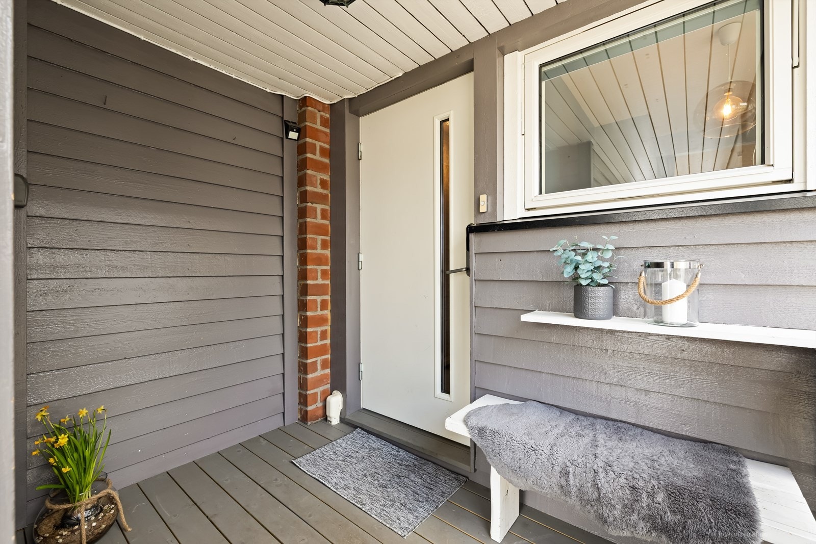 Trivelig takoverbygget inngangsparti med terrasseplatting. Galleribilde