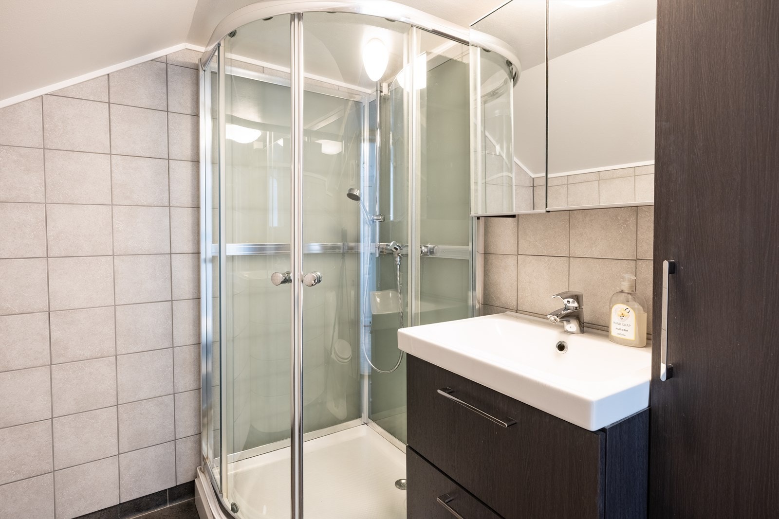 Begge badene er utstyrt med dusjkabinett, opplegg til vaskemaskin og servantskap. Galleribilde