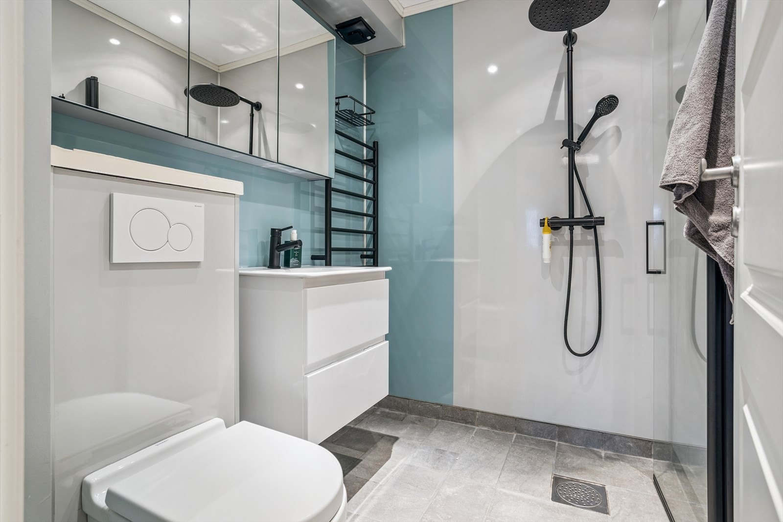 Pent og moderne bad med oppgraderinger fra 2022. Her ble det meste av badet oppgradert, inkludert nye baderomsplater og baderomsmøbler. Badet inneholder vegghengt toalett, håndvask med skap og ellers dusj med dør av glass. Elektrisk vifte, og ellers till Galleribilde