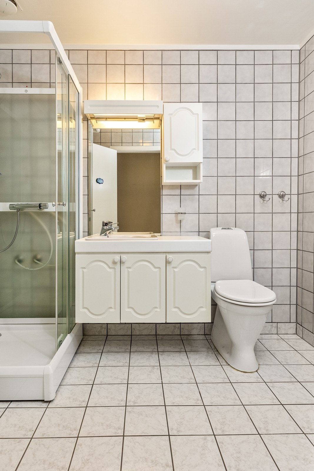 Badet er videre utstyrt med toalett og et dusjhjørne med glassdører. Opplegg for vaskemaskin. Galleribilde