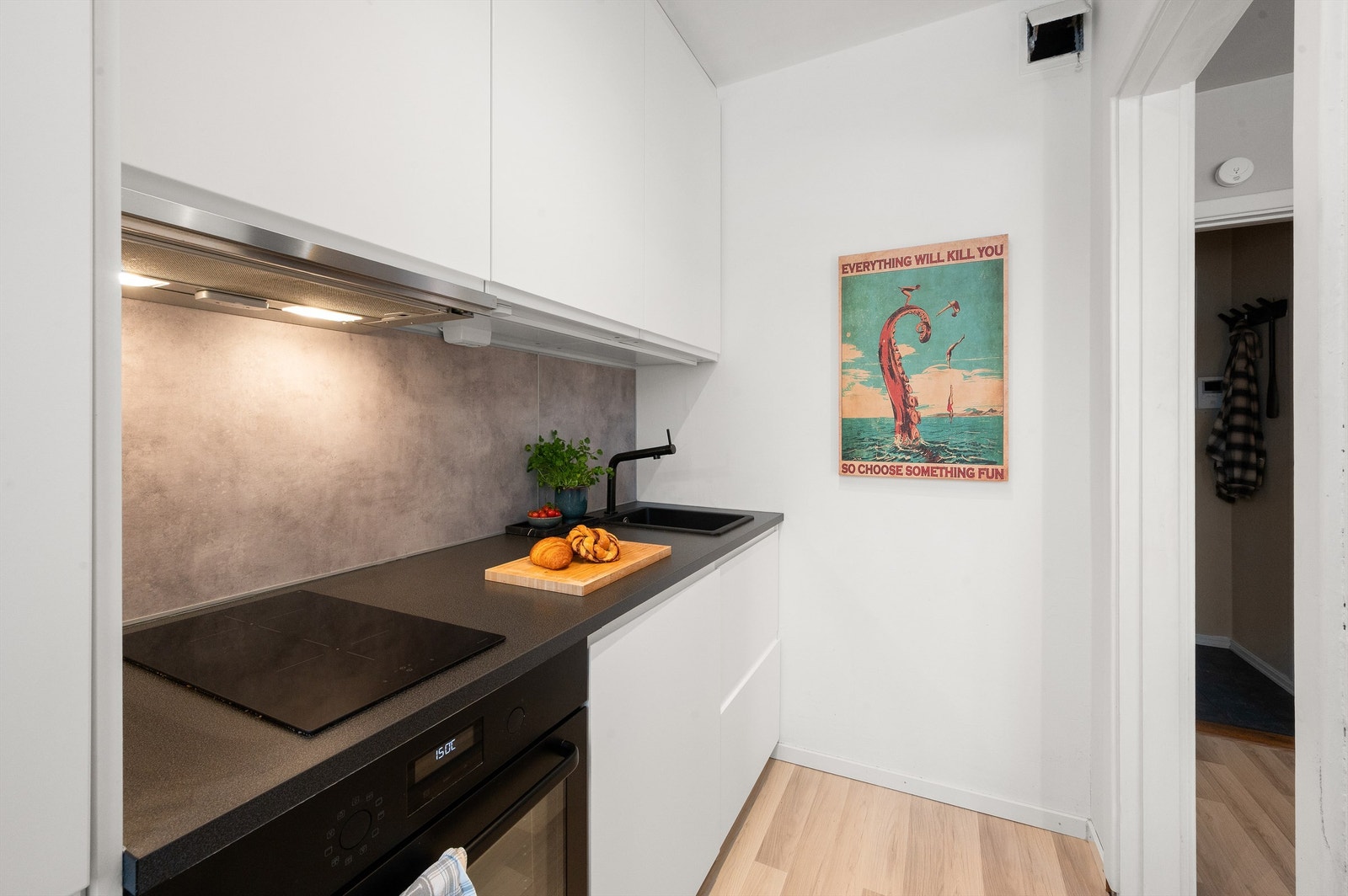 Fra stuen kommer man inn på kjøkkenet som er for mange hjemmets hjerte. Kjøkkenet er adskilt fra stuen og fremstår lekkert og eksklusivt med glatte fronter i hvitt. Galleribilde