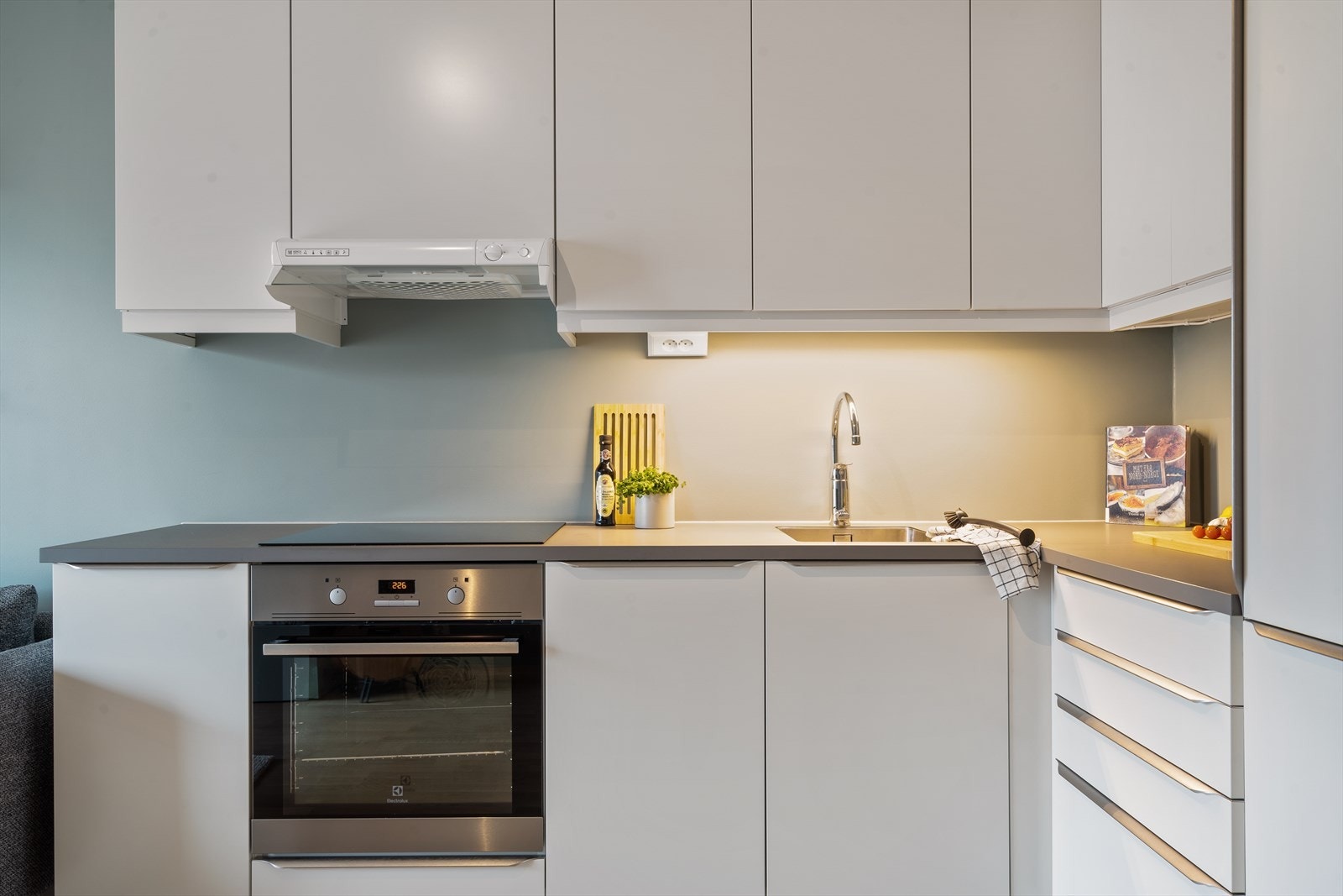 Et L-formet kjøkken gir gode arbeidsflater, og har ofte større praktisk verdi enn man skulle tro. Arealet er godt utnyttet. Integrerte hvitevarer medfølger i handelen. Galleribilde