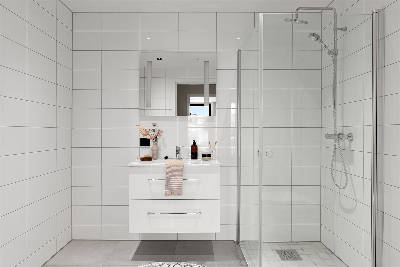 Bad nummer to som også er helfliset med vegghengt wc, dusjhjørne, baderomsinnredning i hvit utførelse og varme i gulv. Galleribilde