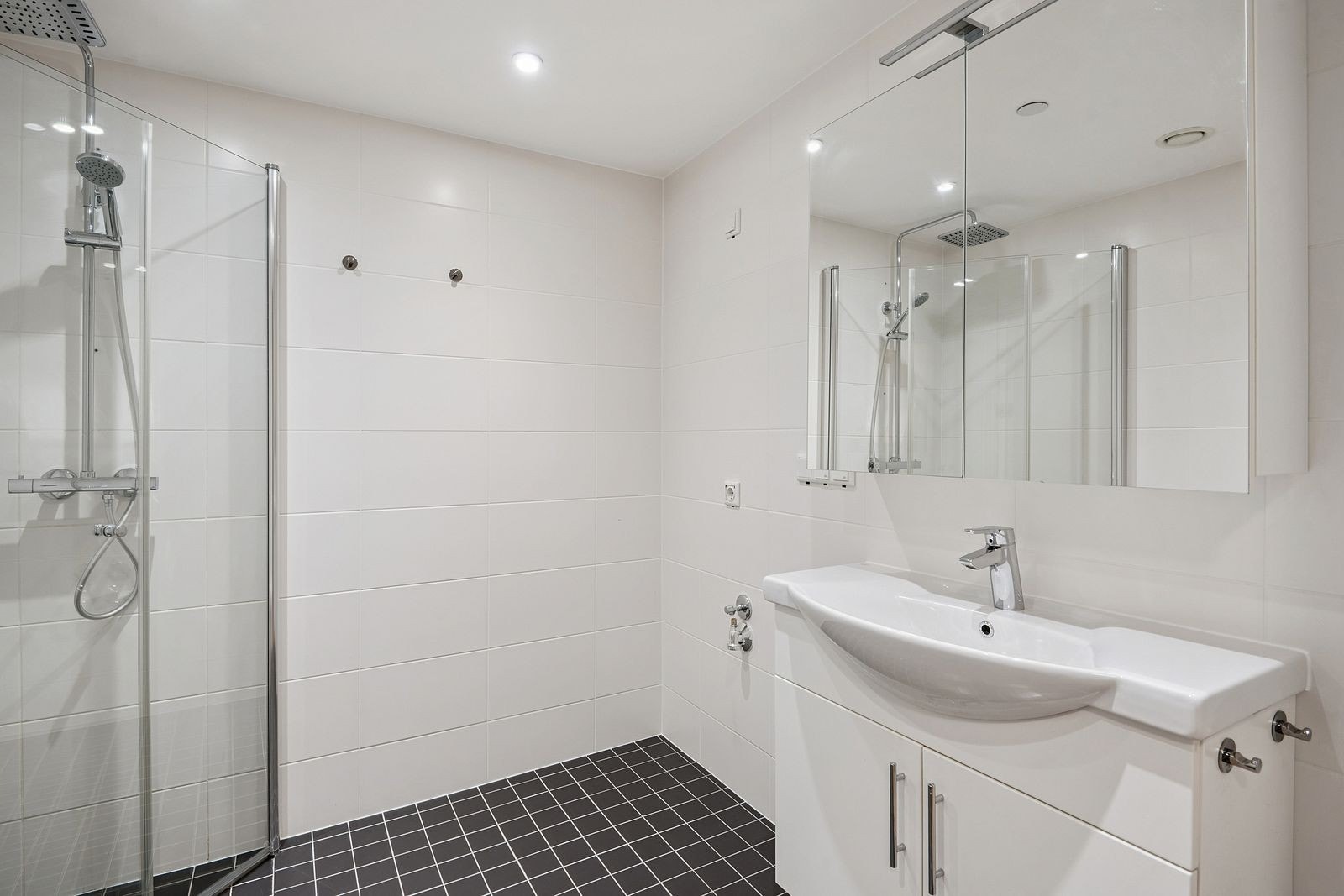 Lekkert flislagt bad med dusjhjørne, opplegg for vaskemaskin og gulvvarme. Galleribilde