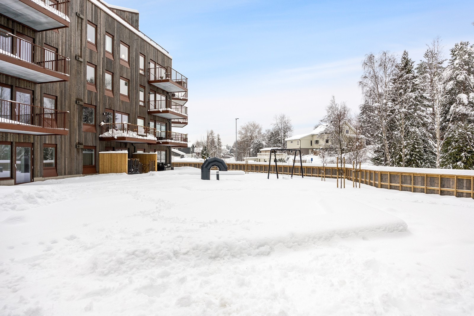 Fellesområdet er pent opparbeidet med plen og lekeapperater. Galleribilde