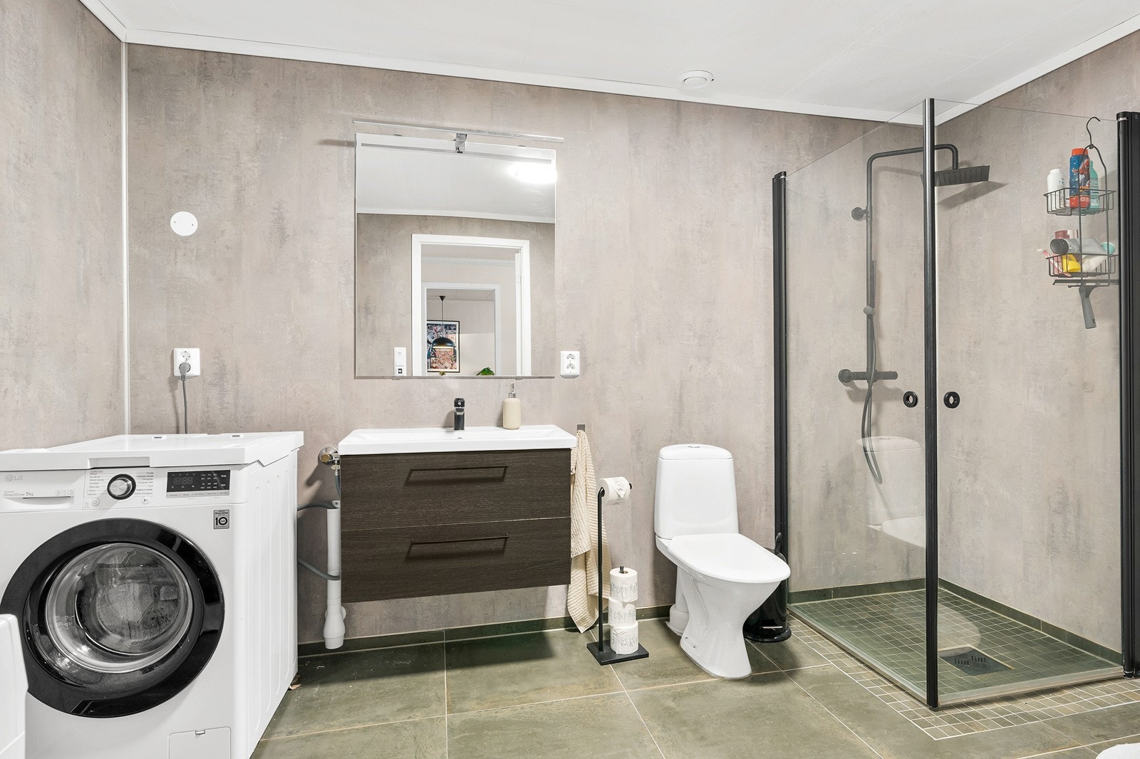 Romslig bad med baderomsplater på veggene, flislagt gulv og himlingen har malte plater. Galleribilde