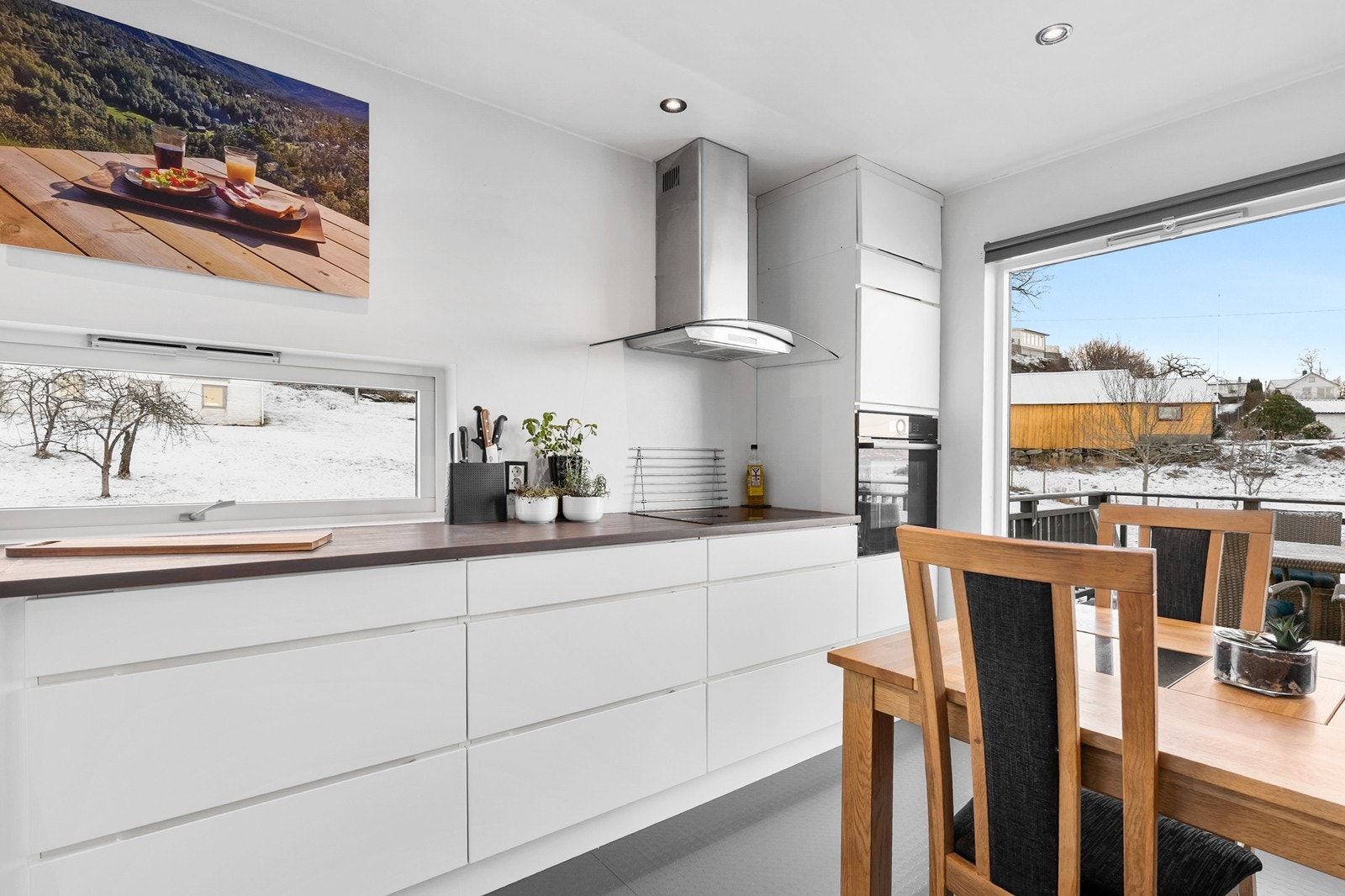 Kjøkkeninnredning fra Kvikk med glatte fronter og benkeplate i heltre gir et stilrent og tidløst uttrykk. Galleribilde