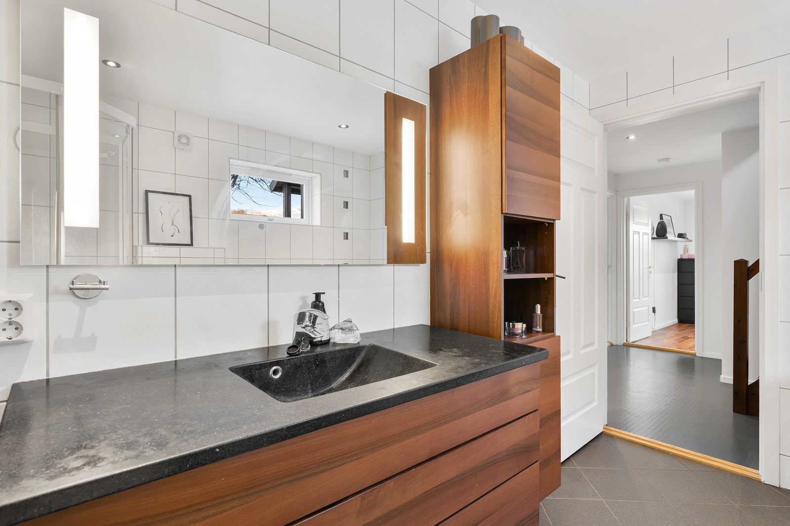 Stort og innholdsrikt bad med flislagt gulv med varmekabler, fliser og malte plater på vegger samt spotter i tak. Galleribilde