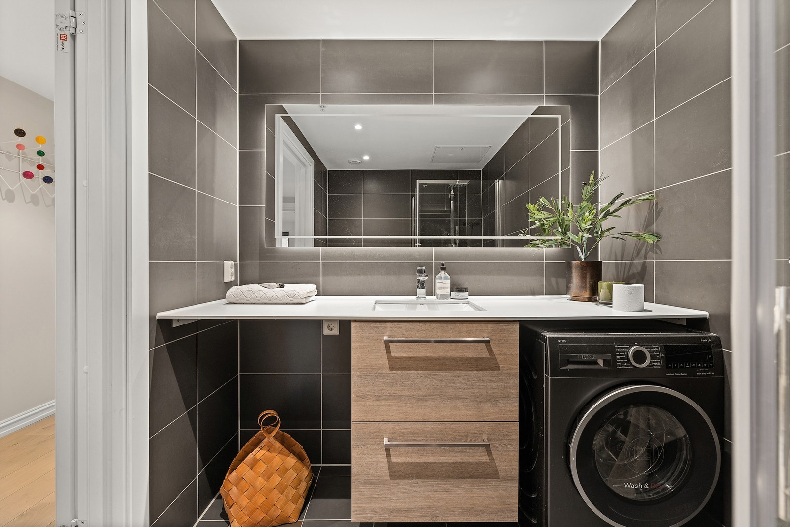 Det flislagt badet har varmekabler i gulv og opplegg for vaskemaskin og tørketrommel Galleribilde