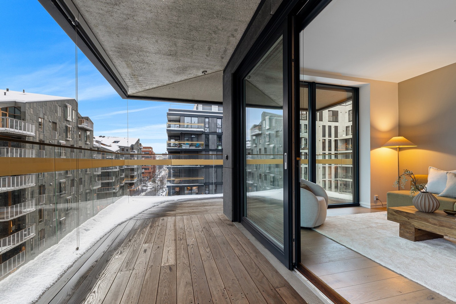 Vinklet sørvestvendt overbygget balkong på rundt 21m2 med utgang fra stue, med egen elektrisk solavskjerming ved glassrekkverket Galleribilde