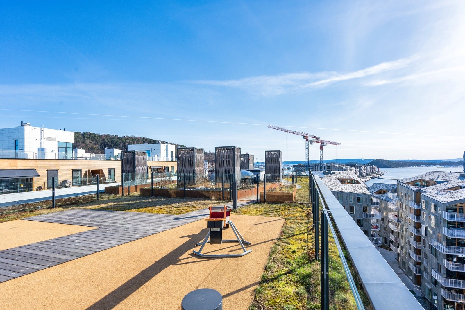 Takterrassen er pent opparbeidet med plenarealer, dyrkningskasser, fin beplantning og enkelte lekeapparater Galleribilde