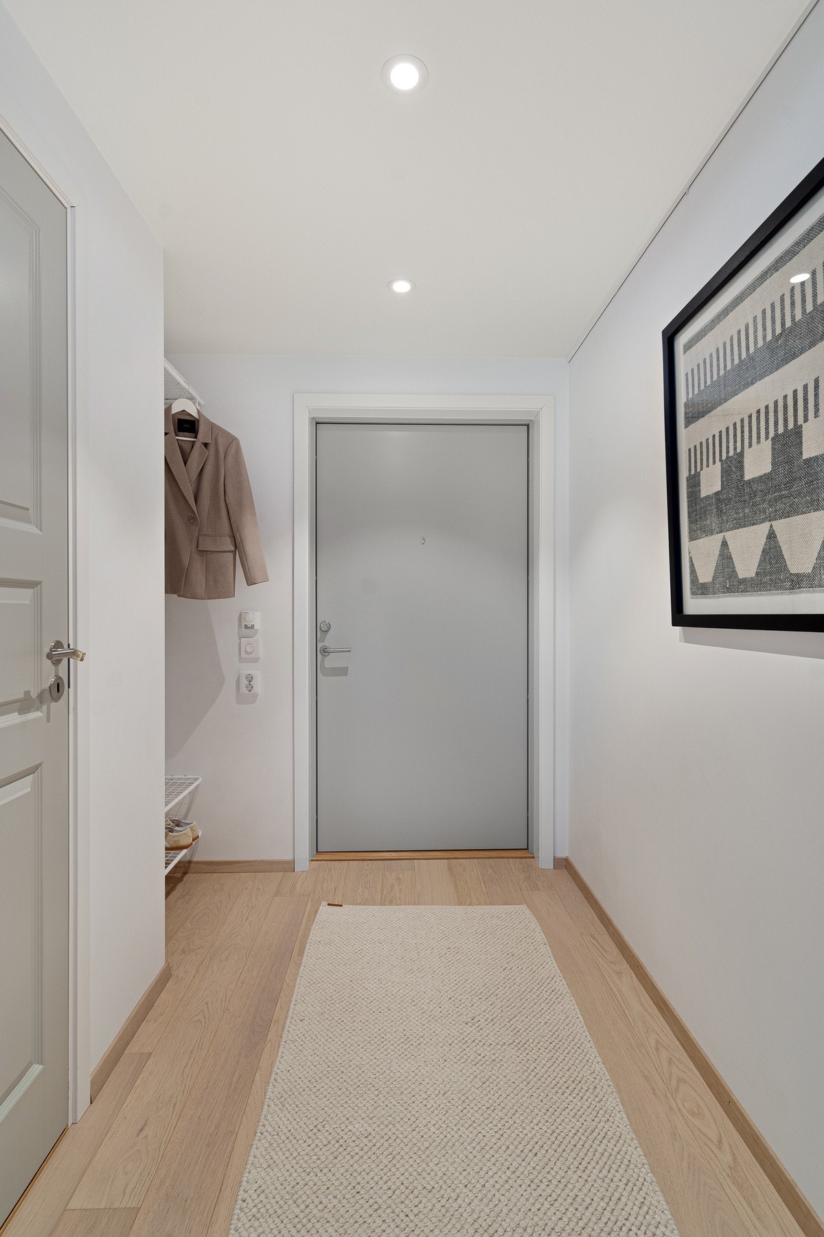 Leiligheten ønsker deg velkommen med en lys og moderne entré med god plass til yttertøy og sko. Allerede ved inngangsdøren får man et godt inntrykk av boligens gjennomgående stil og gjennomtenkte materialvalg. Galleribilde
