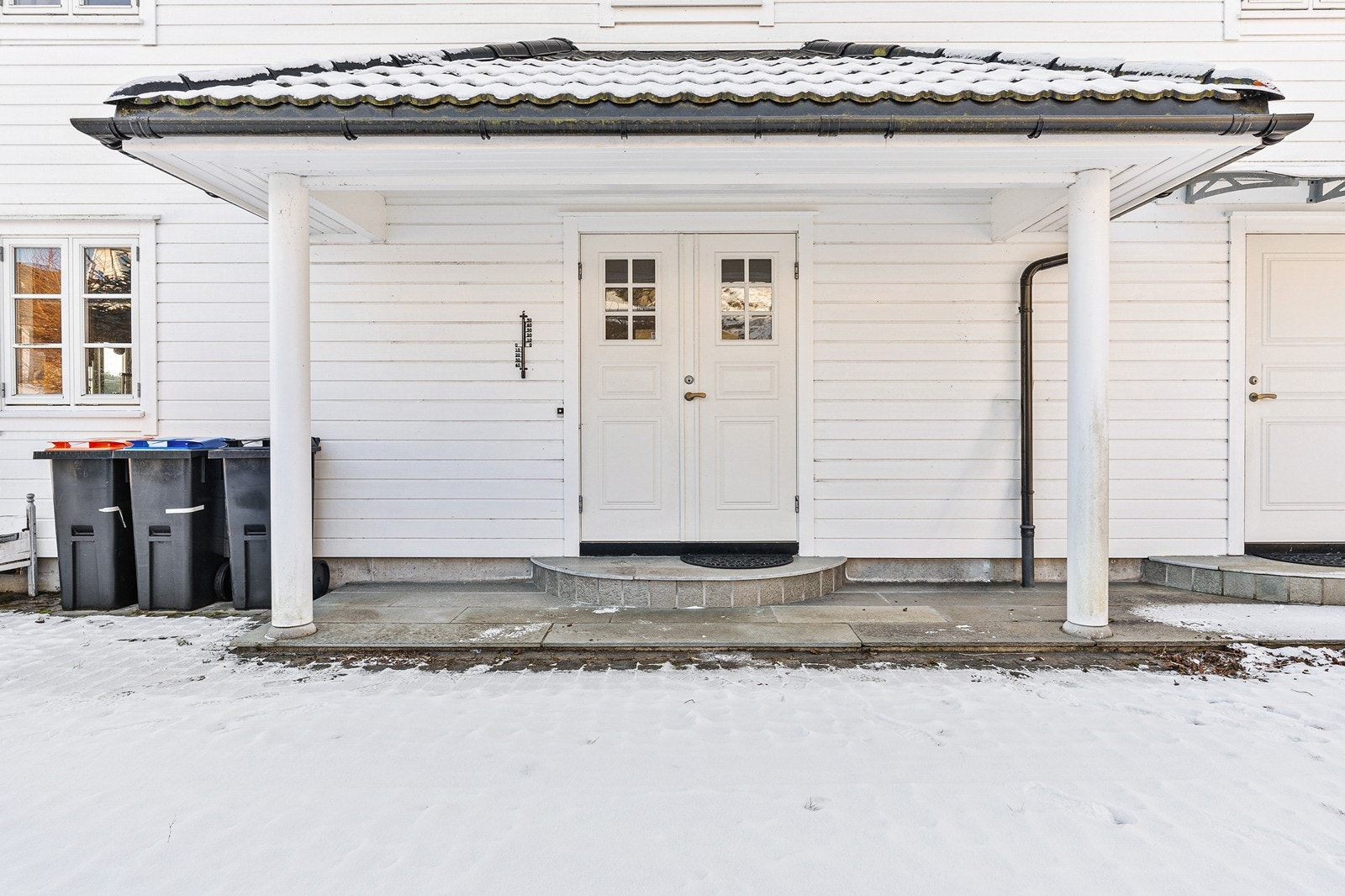 Pent inngangsparti med søyler i front og takoverbygg. Galleribilde